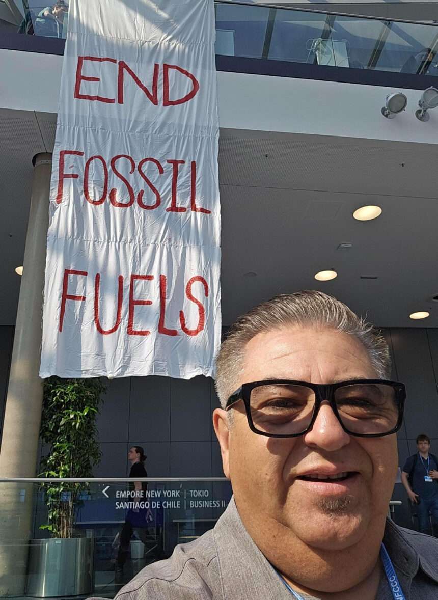Jose Bravo with banner "End Fossil Fuels"