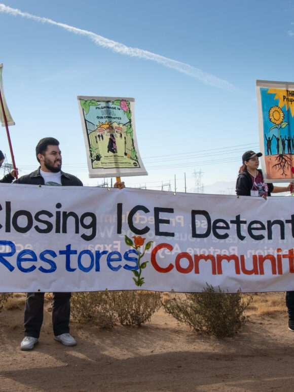 group of people with banner "Close ICE Detention, Restore Communities"