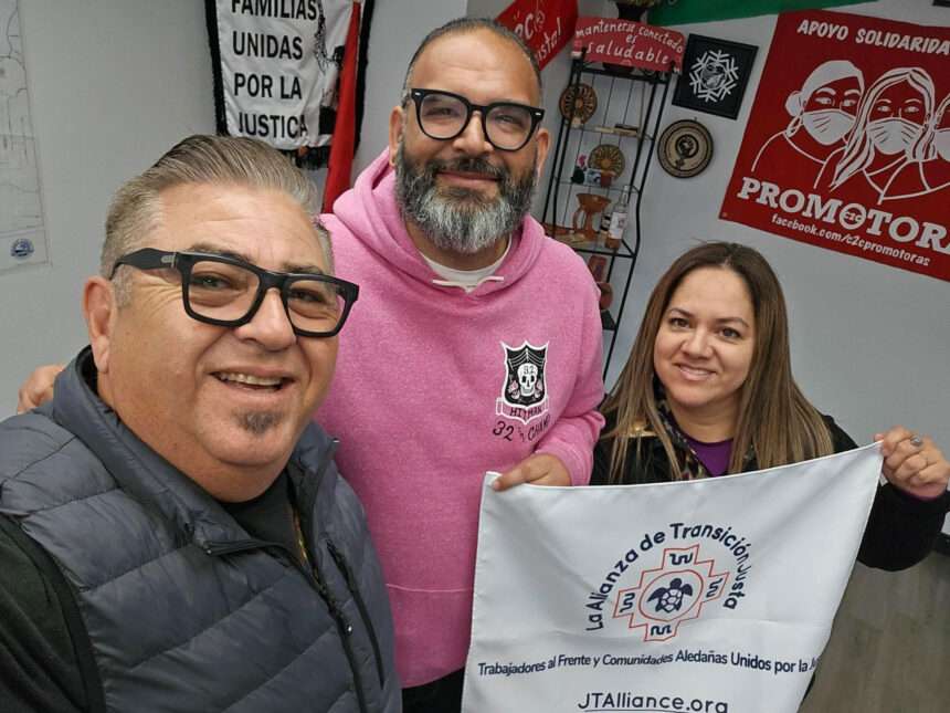 three people posing with a banner "La Alianza de Transicion Justa"